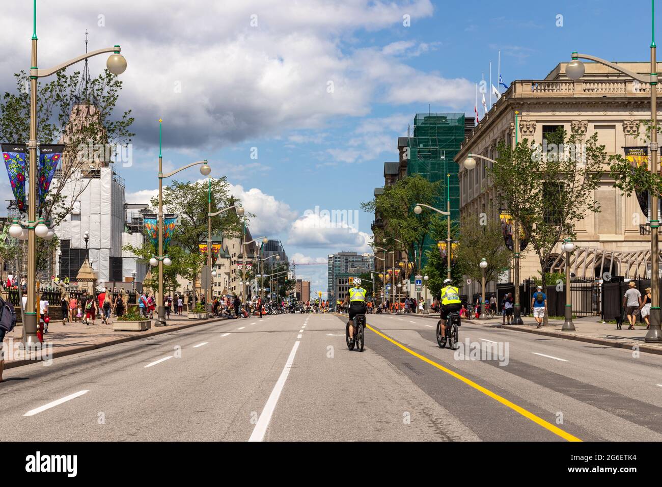 Ottawa, Kanada - 1. Juli 2021: Blick auf die Straße von Wellington mit Wanderern und Polizisten auf Fahrrädern in der Innenstadt von Ottawa. Straße für Autos gesperrt Stockfoto