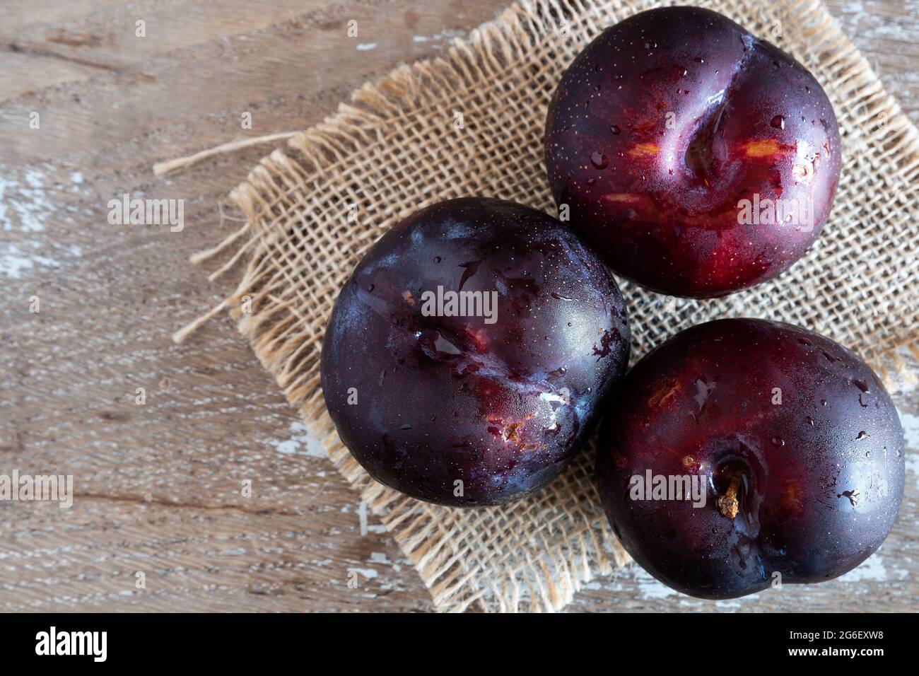 Frische Obstpflaumen auf rustikalem Hintergrund Stockfoto