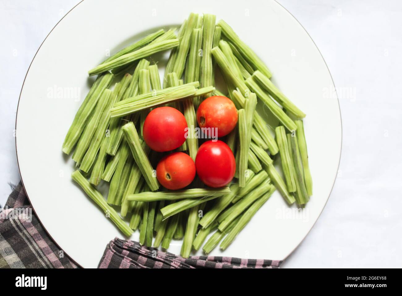 Tomaten mit Drumstick-Stücken auf weißem Teller, Draufsicht, leckeres Essen Stockfoto