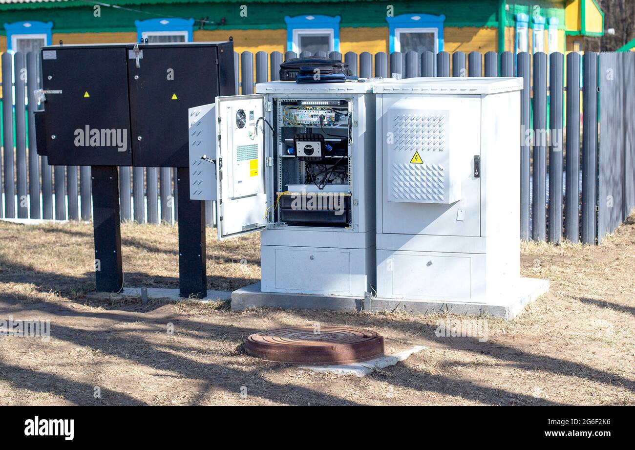 Elektrischer Schrank mit Strom auf dem Hintergrund eines Privathauses. Stromversorgung des Dorfhauses Stockfoto