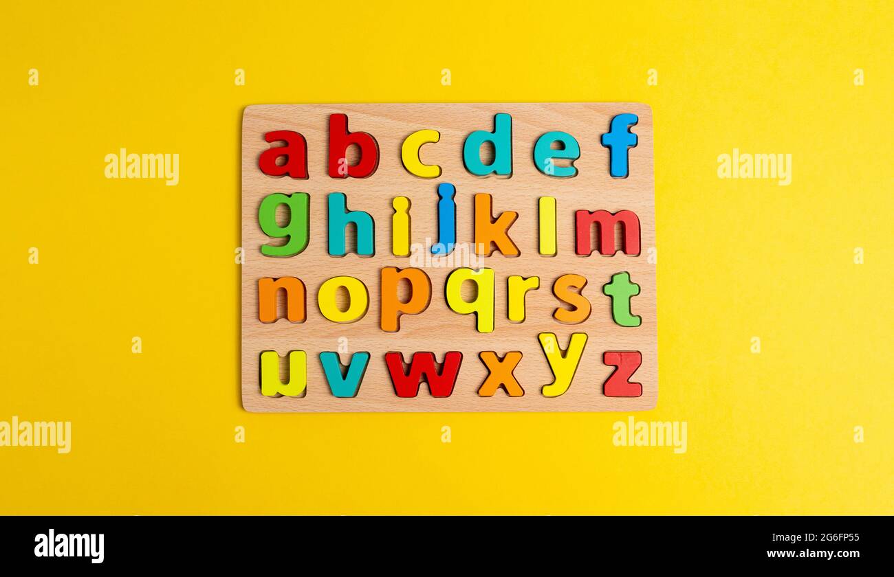 Draufsicht Foto mehrfarbige Buchstaben des englischen Alphabets auf gelbem Hintergrund. Unterrichten von Kindern Stockfoto