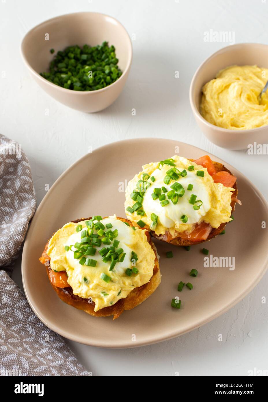 Leckeres herzhaftes Frühstück, Eier Atlantic in einem Teller auf weißem Hintergrund, Runde gebratene Brötchen mit Lachs und Eier Benedikt, Sauce Hollandaise Stockfoto