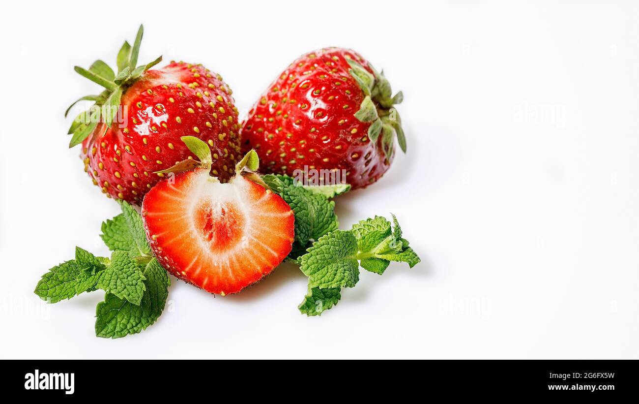 Süße, saftige Erdbeeren und Minzblätter. Reife Erdbeeren und frische Minze auf weißem Hintergrund. Lebensmittelbanner. Bio fettfreie, kalorienarme Lebensmittel. Cop Stockfoto