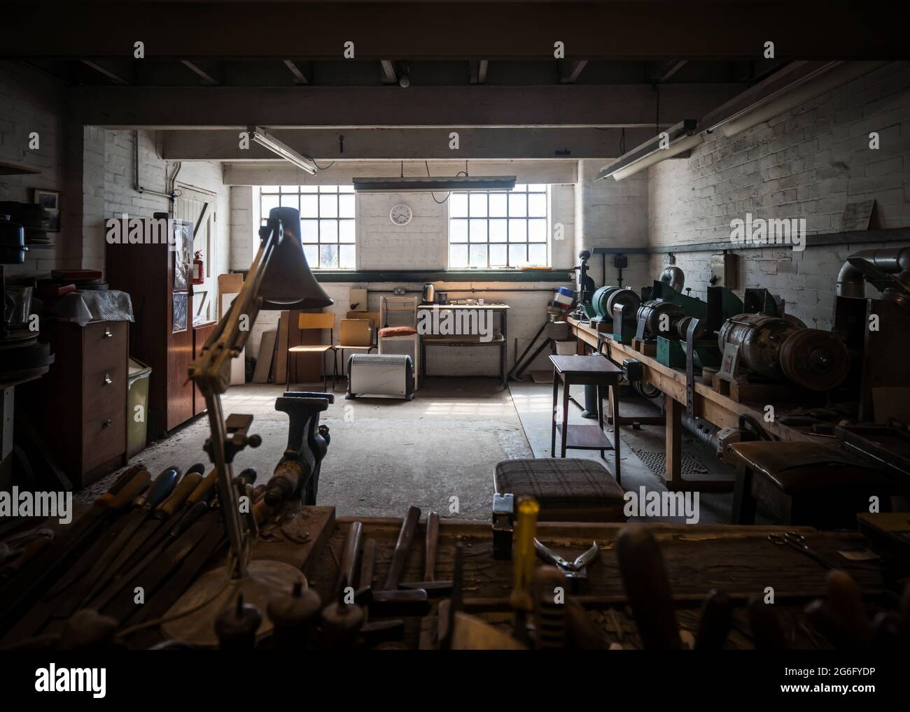 Verlassene alte Werkstatt, schmutziges Zimmer, staubig und menschenleer.  Industrie und Werkzeuge sitzen ungenutzt, stimmungsvoll und gruselig  unheimlich natürliches Licht. Handwerkskunst Stockfotografie - Alamy