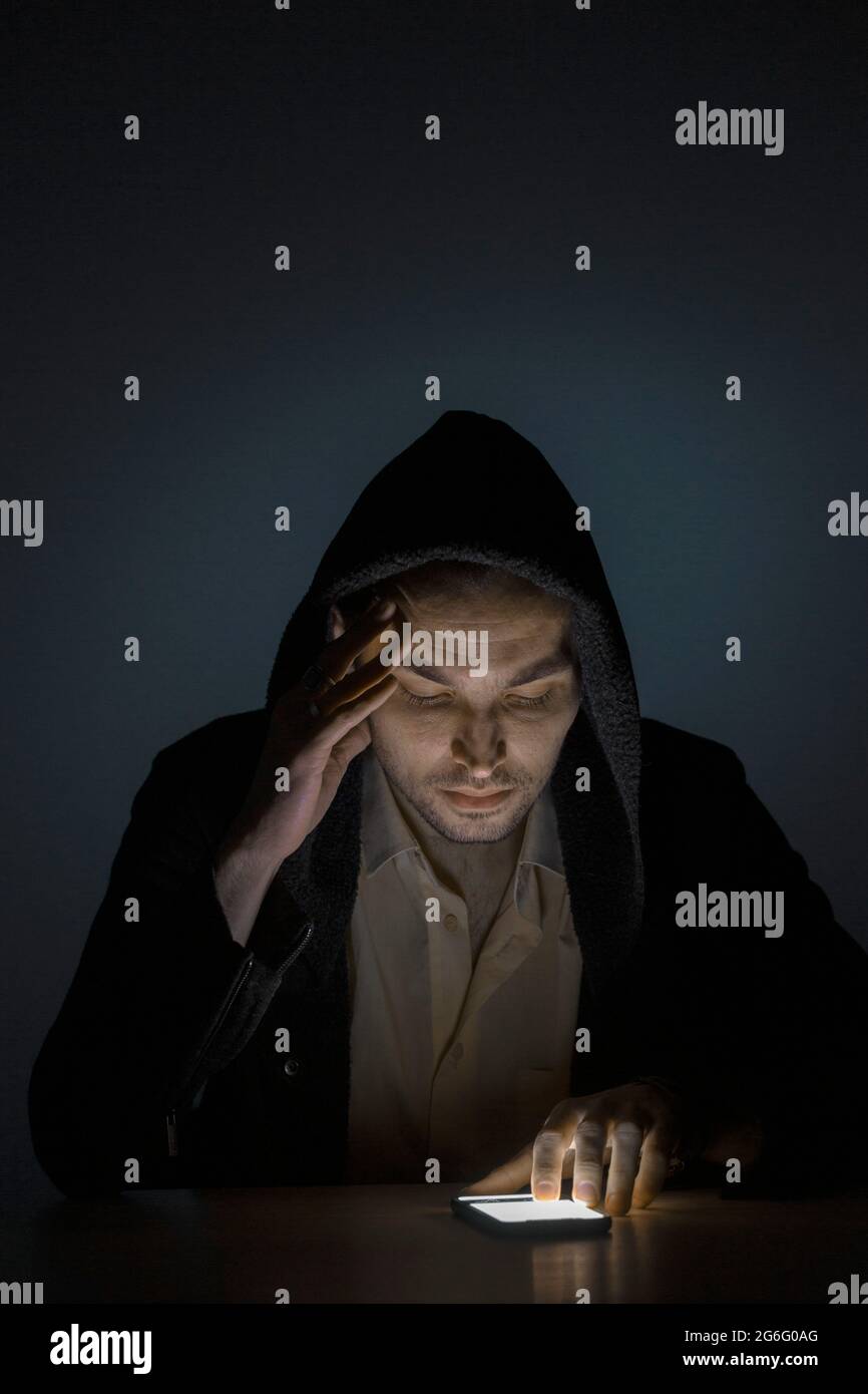Mann mit Smartphone im Dunkeln Stockfoto