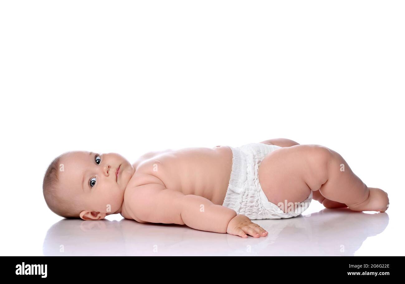 Kleinkind Kind Baby Mädchen Kind in Windel liegt auf ihrem Rücken seitlich zur Kamera und Blick auf Kamera isoliert auf weiß Stockfoto