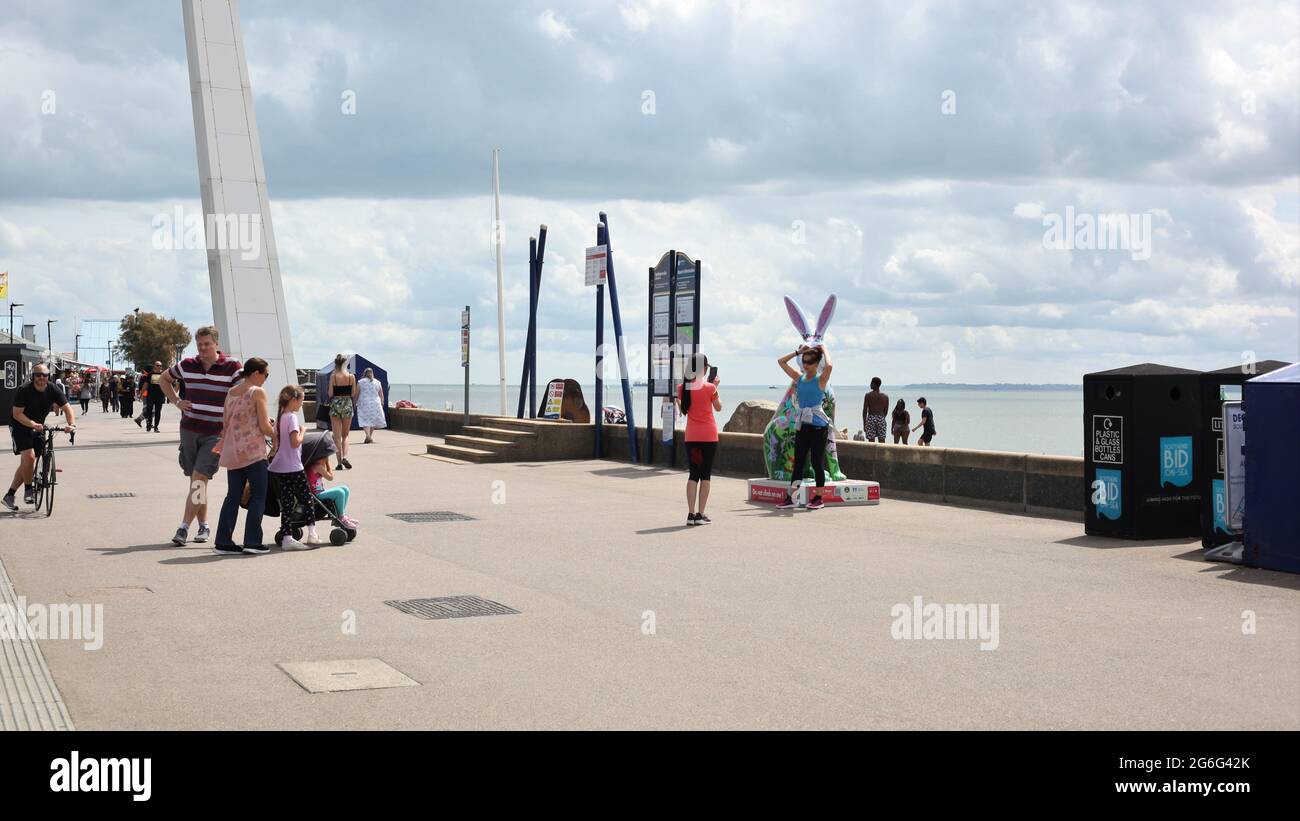 Junge Mädchen stehen neben einer der farbenfrohen Hare-Skulpturen, die Teil des Southend-on-Sea's Arts Trail, Southend-on-Sea, Essex, Großbritannien, sind Stockfoto