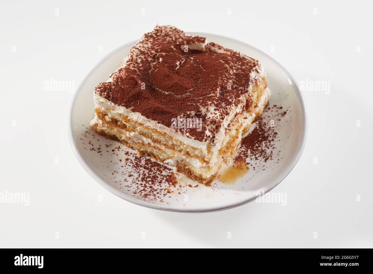 Von oben ein Stück appetitlichen Tiramisu Kuchen serviert auf dem Teller auf weißem Hintergrund Stockfoto