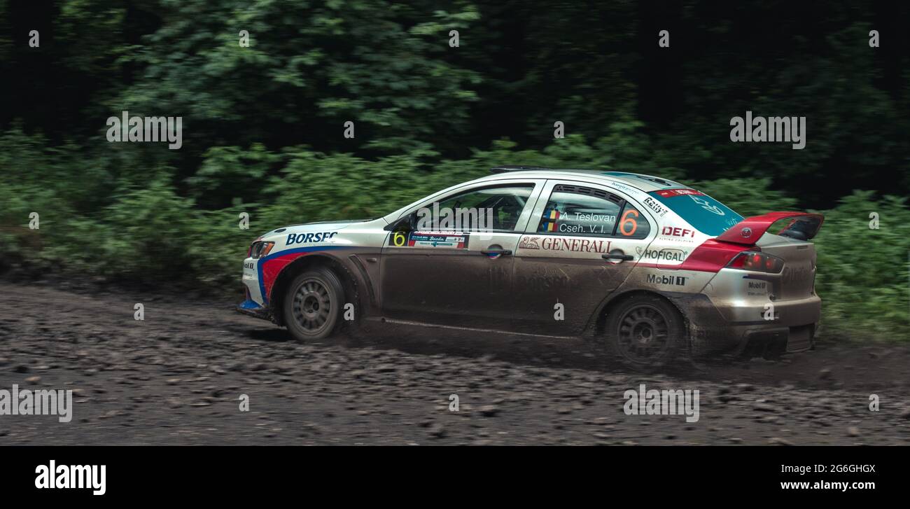 Action-Aufnahme eines Rallyewagens während eines Wettkampfs auf schlammigen forst-Strecken Stockfoto