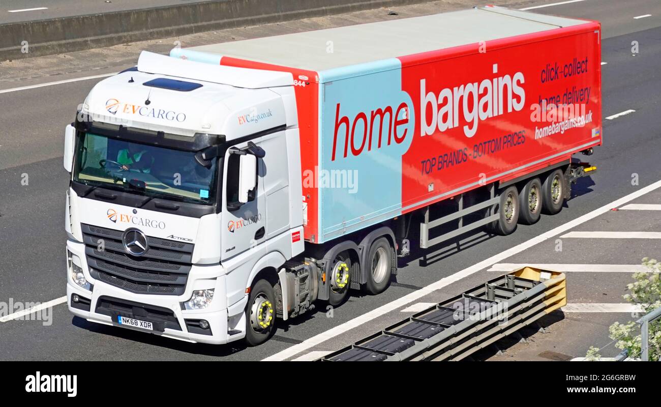 Seite & Vorderansicht Startseite Schnäppchen Werbung auf der Lieferkette des Ladens artikulierter Anhänger hinter dem weißen LKW-Logistik-LKW auf der britischen Autobahn Stockfoto