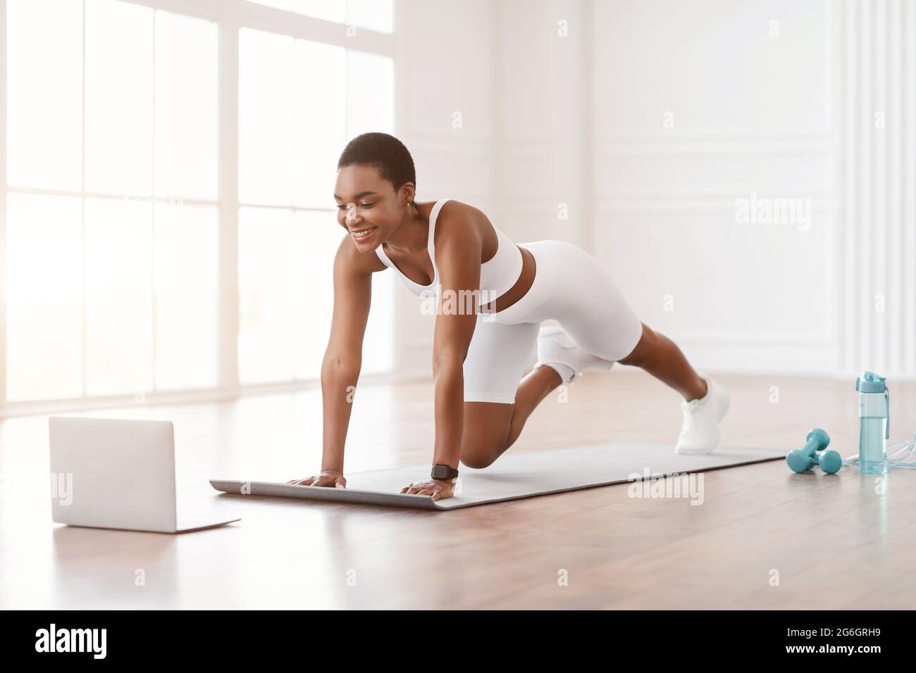 Fröhliche Afro-Frau Beim Training Von Cross Body Mountain Kletterern Stockfoto