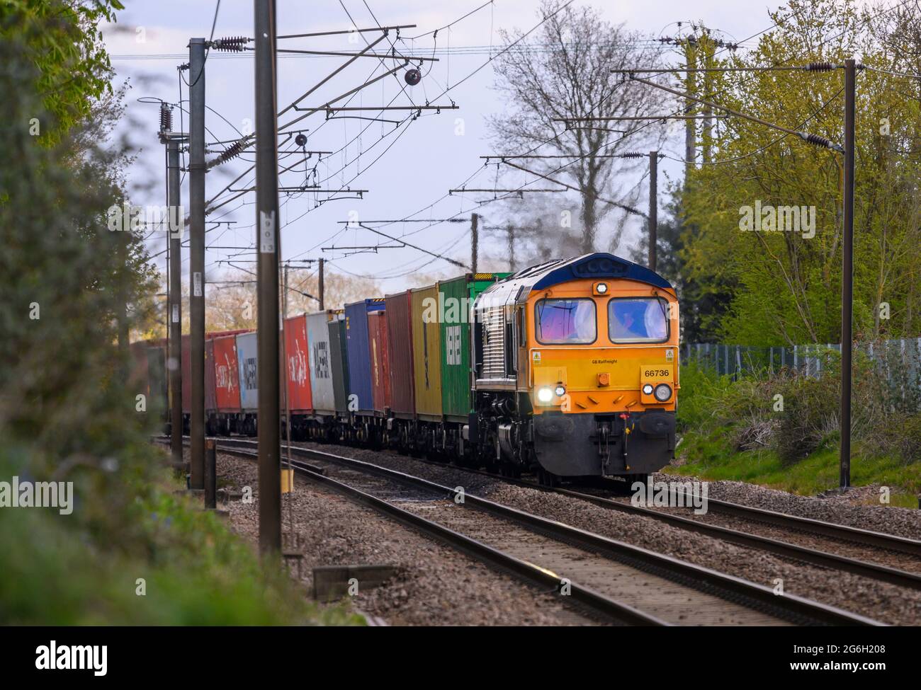Lokomotive der Baureihe 66 in GB Railfreight Lackierung, die Frachtcontainer in Essex, England transportiert. Stockfoto