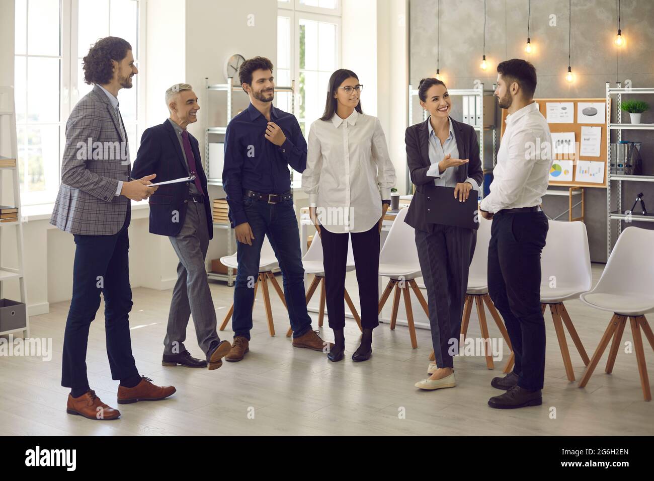 Lächelnd verschiedene Büroangestellte unterhalten sich bei einer Besprechung im Büro angenehm. Stockfoto