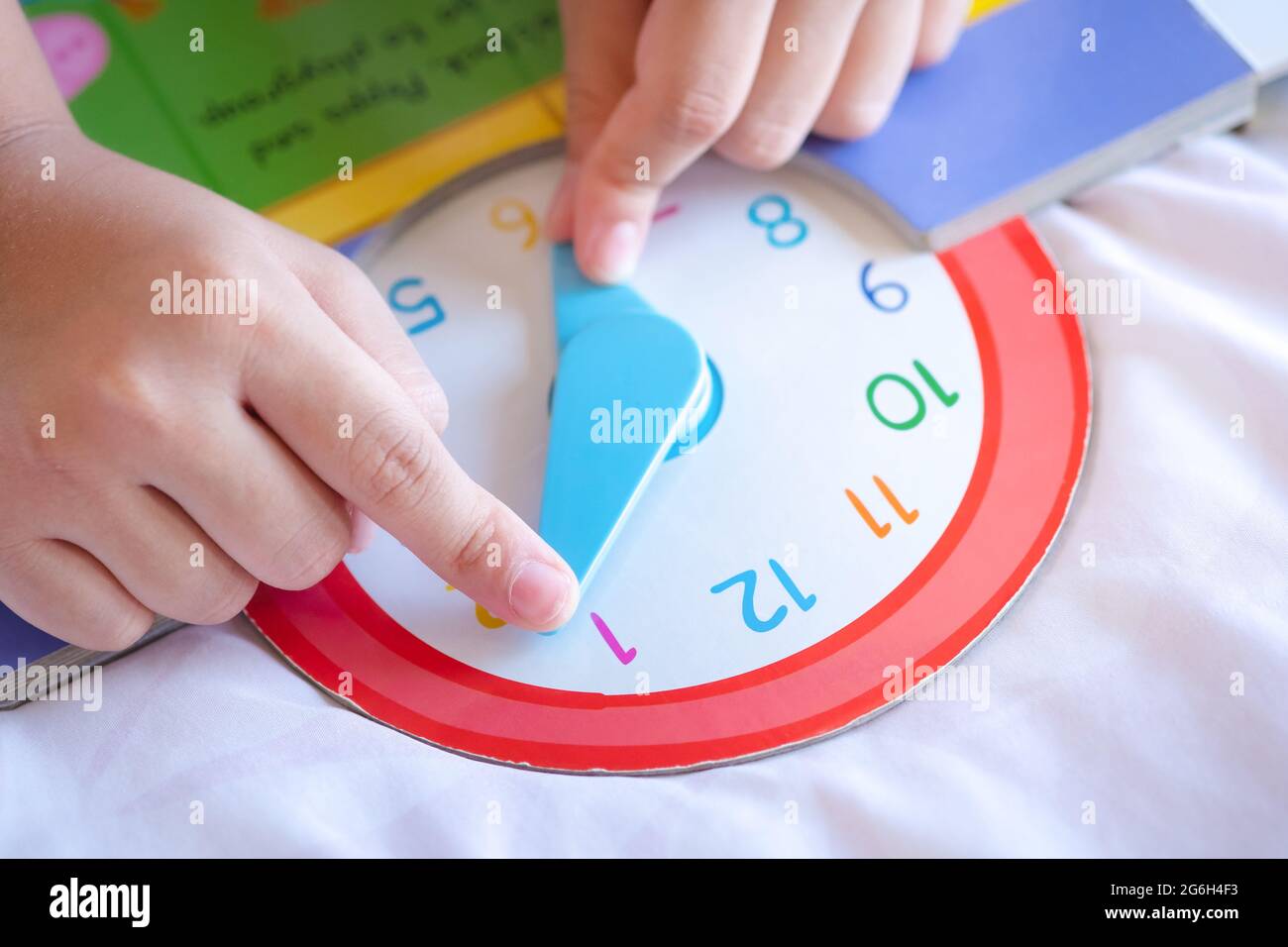 Kind spielen sagen Zeit Spiel, kleine Kinder zu lernen, wie man eine analoge Uhr zu lesen. Stockfoto