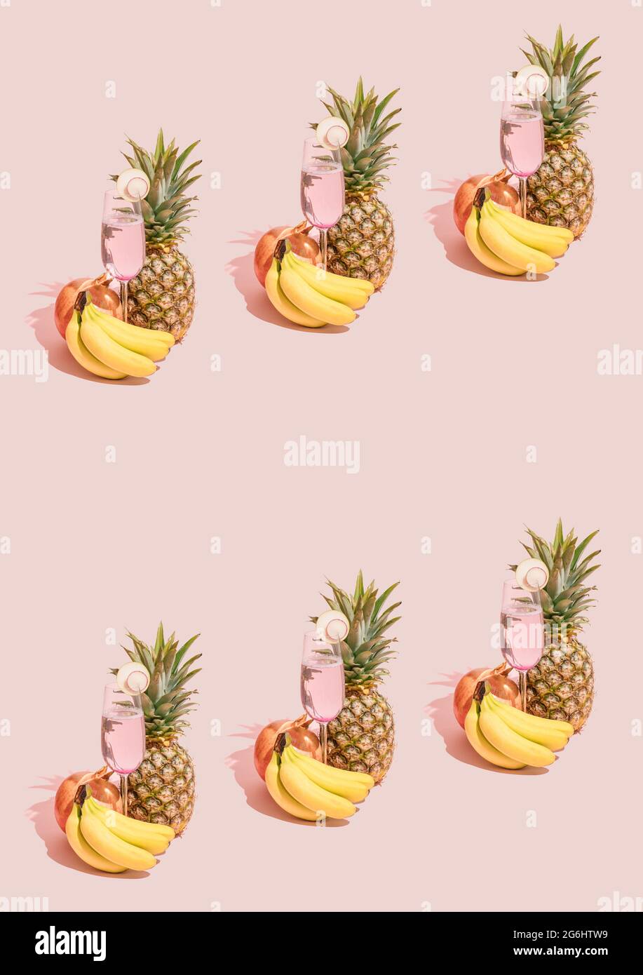 Kreatives Muster aus frischen Bananen, Ananas, Granatapfel und Erfrischungssaft im Glas auf pastellrosa Hintergrund. Natürlicher grüner Pflanzenschatten. S Stockfoto