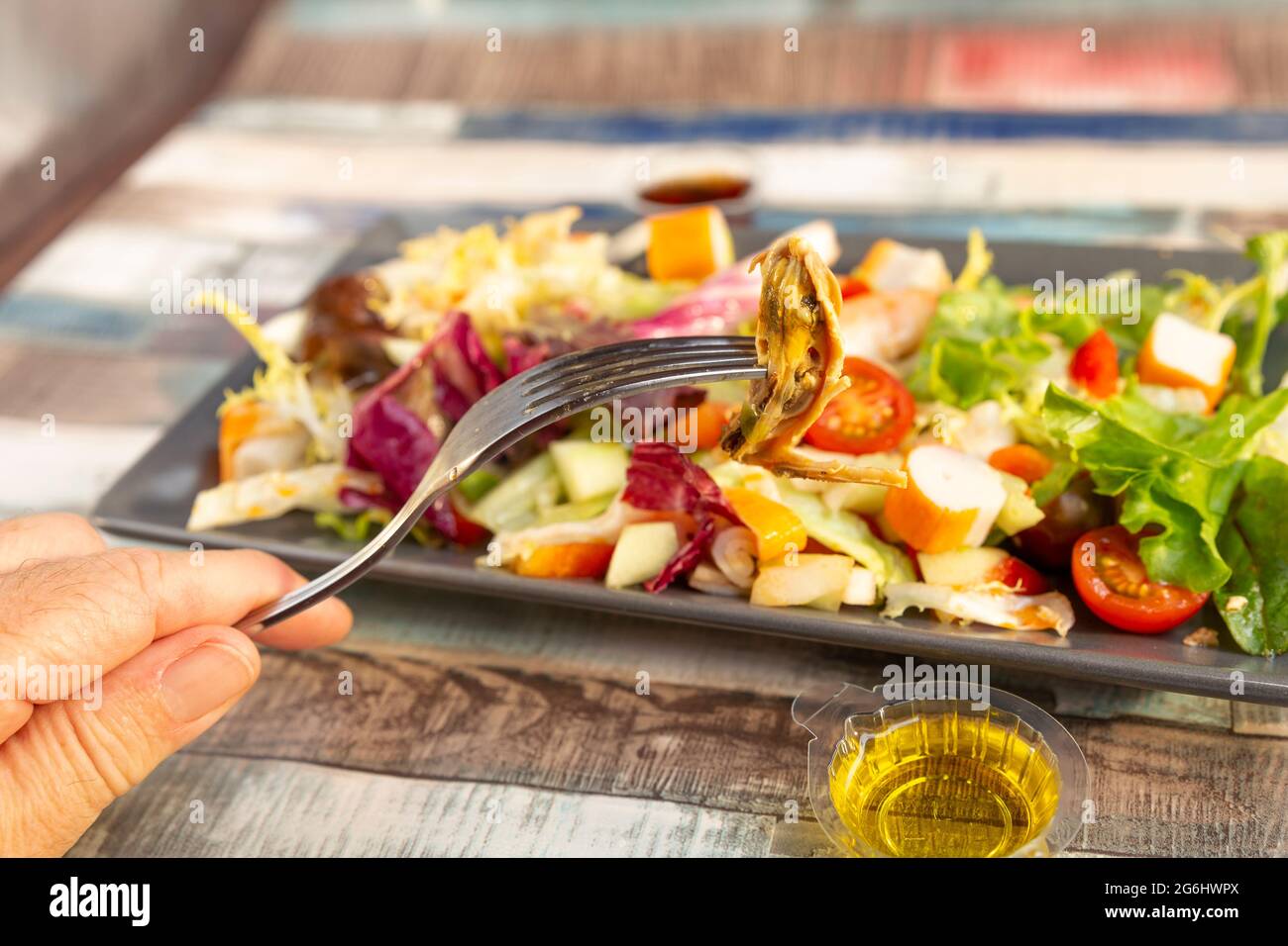 Blick auf Muschel auf einer Gabel und gemischter Salat mit Meeresfrüchten Stockfoto