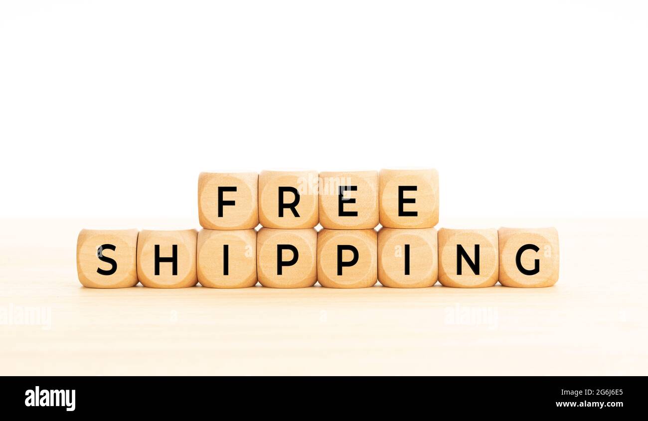 Kostenlose Versandphrase in Holzblöcken auf dem Tisch. Weißer Hintergrund. Speicherplatz kopieren Stockfoto
