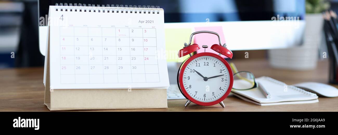 Kalender für April 2021 ist auf dem Desktop neben Alarm Uhr Stockfoto