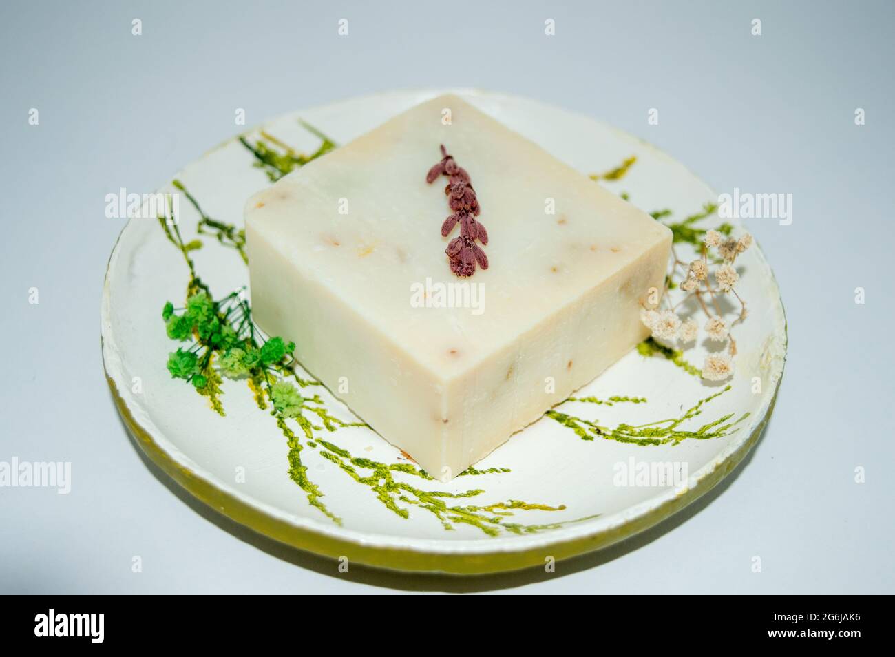 Handgemachte Keramikplatte und handgemachte Lavendelseife.hausgemachte Seife mit kleinen Blumen.Nahaufnahme Stockfoto