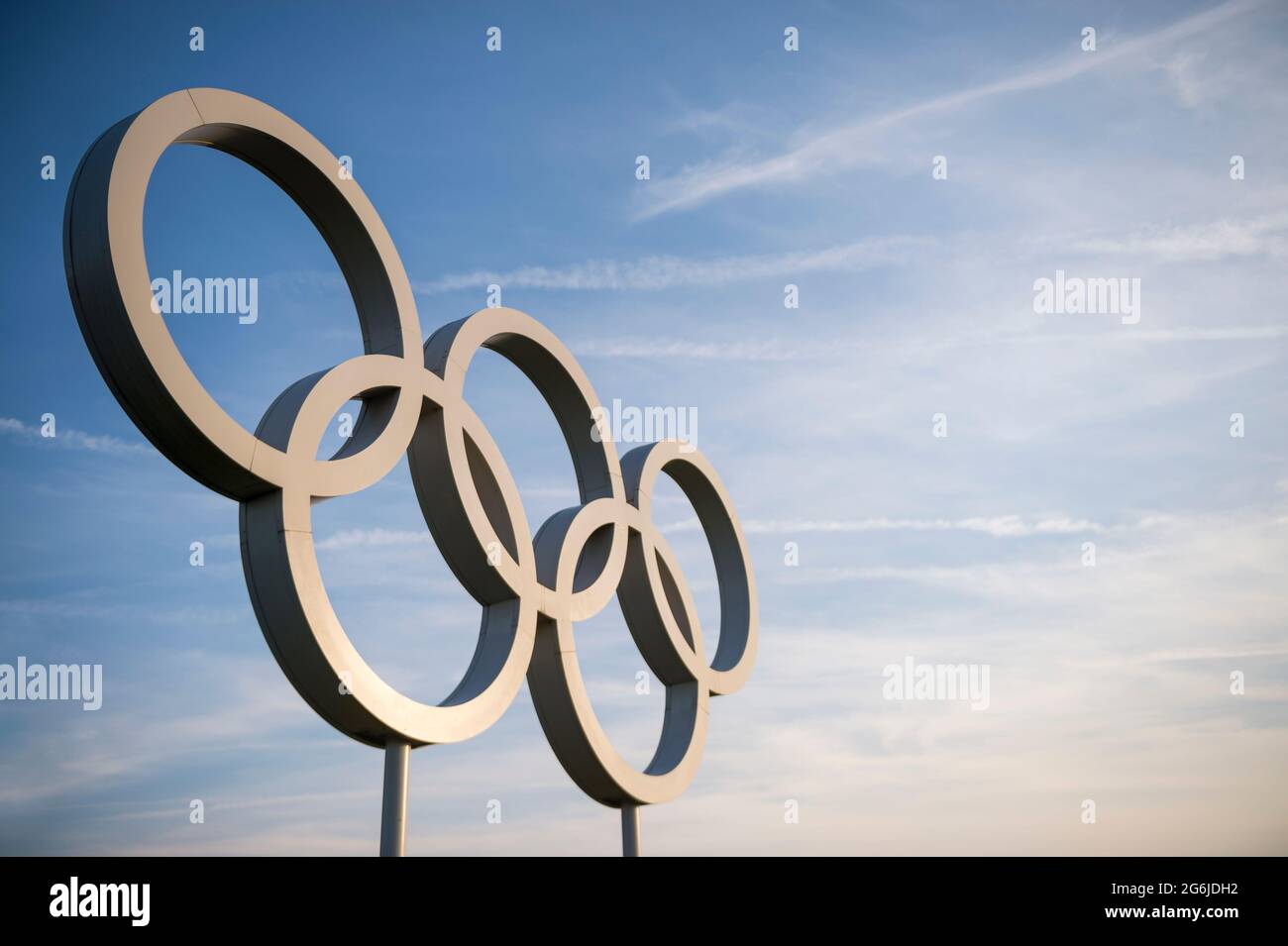 RIO DE JANEIRO - MAI 2016: Die Olympischen Ringe in Metallic-Silber spiegeln die Sonne unter dem trüben blauen Himmel. Stockfoto