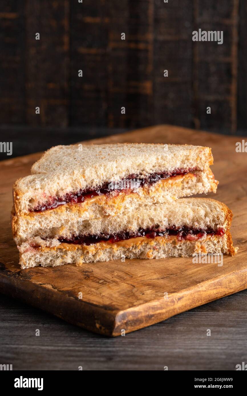 Ein Erdnussbutter- und Traubenjelly-Sandwich auf einem hölzernen Schneidbrett Stockfoto
