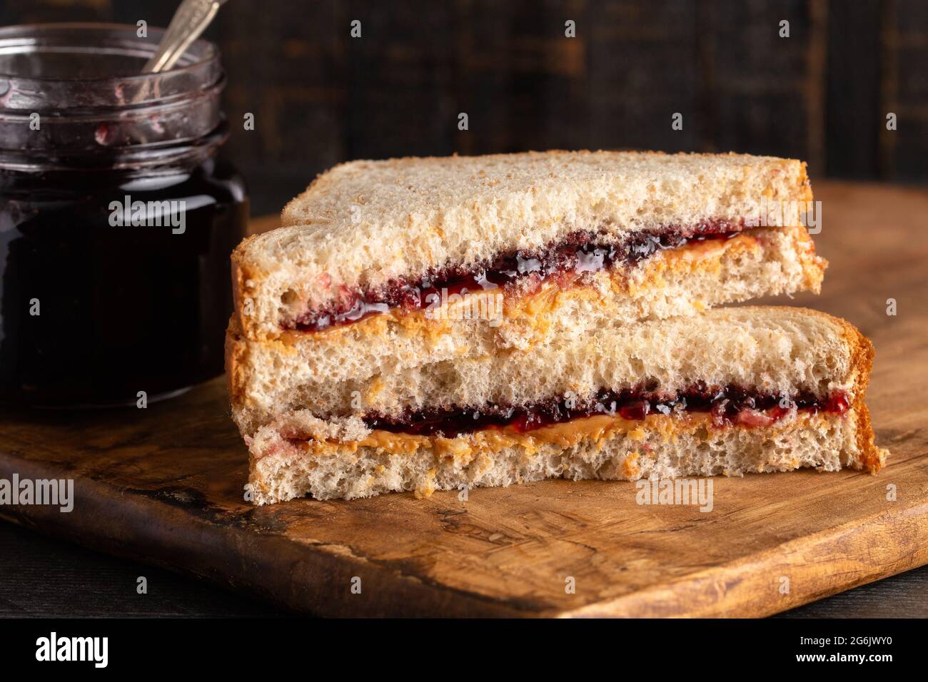 Ein Erdnussbutter- und Traubenjelly-Sandwich auf einem hölzernen Schneidbrett Stockfoto