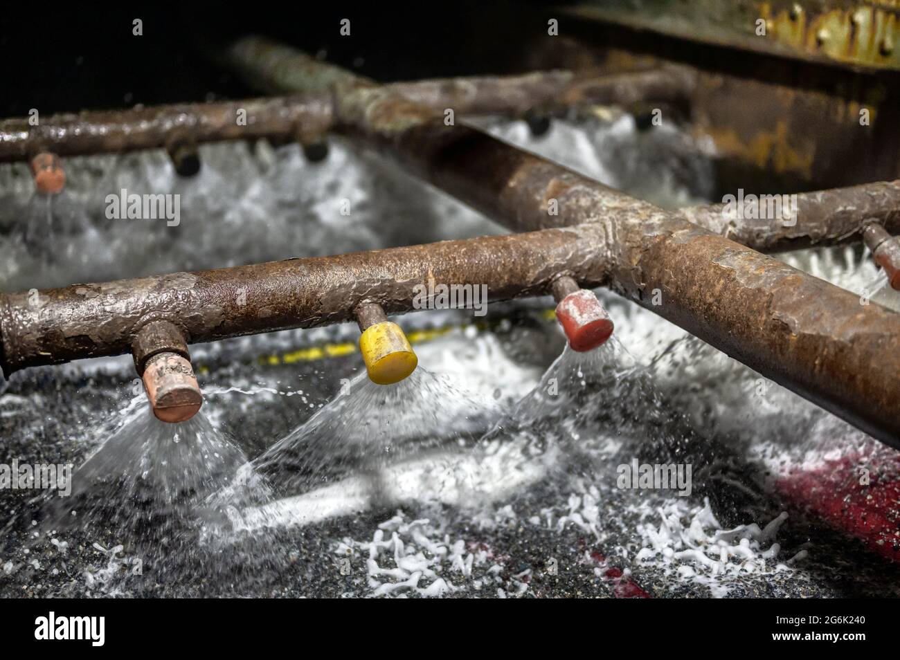 Vibrierende Sieb, Erzwäsche mit Flüssigkeit. Die Flüssigkeit wird in einem fächerähnlichen Strahl aus speziellen Düsen ausgegossen Stockfoto