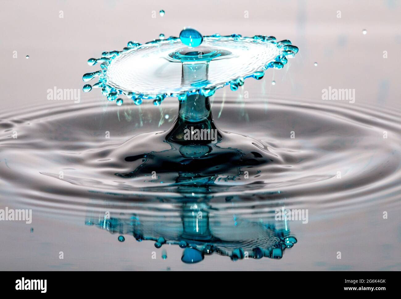 Blaue Wassertropfen Kollision und Reflexion auf einer nahtlosen Oberfläche Stockfoto