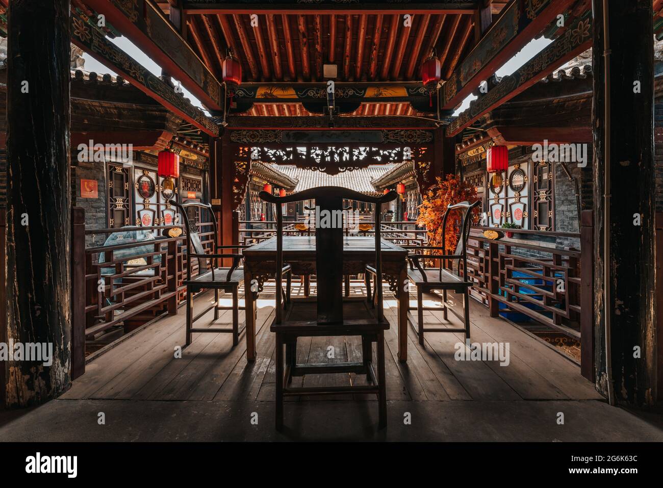 Holzstühle und Schreibtisch in einem alten Holzgebäude in der Altstadt von Pingyao, Provinz Shanxi, mit chinesischer Dekoration, Architektur und Ornamenten Stockfoto