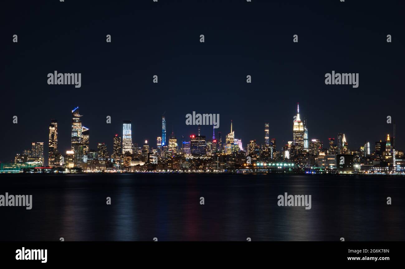 Lower Manhattan von New Jersey über den Hudson River und all die hohen Wolkenkratzer in der Nacht Stockfoto