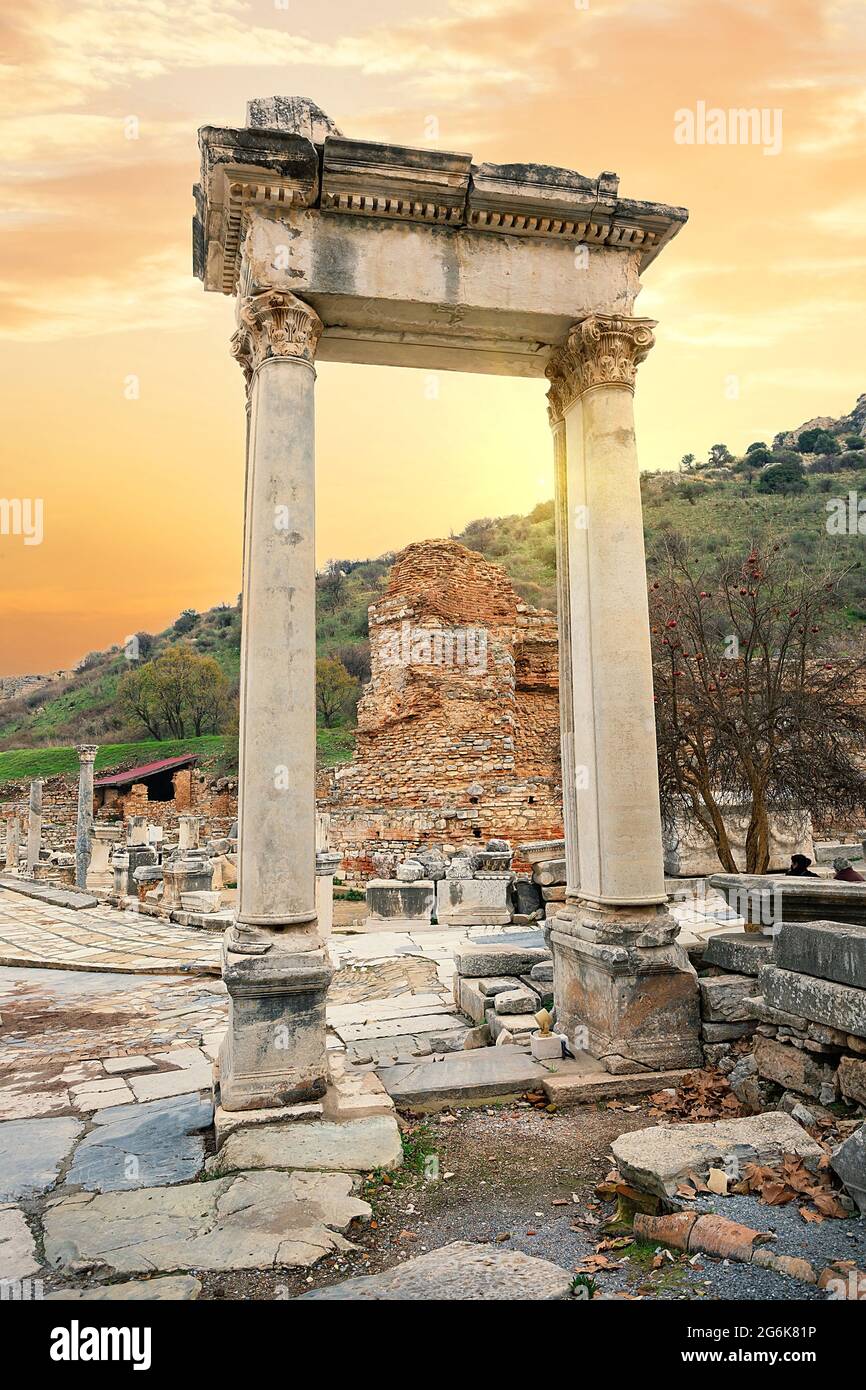 Hadrianstor an der Bibliothek von Celsus bei Sonnenuntergang mit gelbem Himmel. Ephesus, Türkei. UNESCO-Kulturerbe Stockfoto