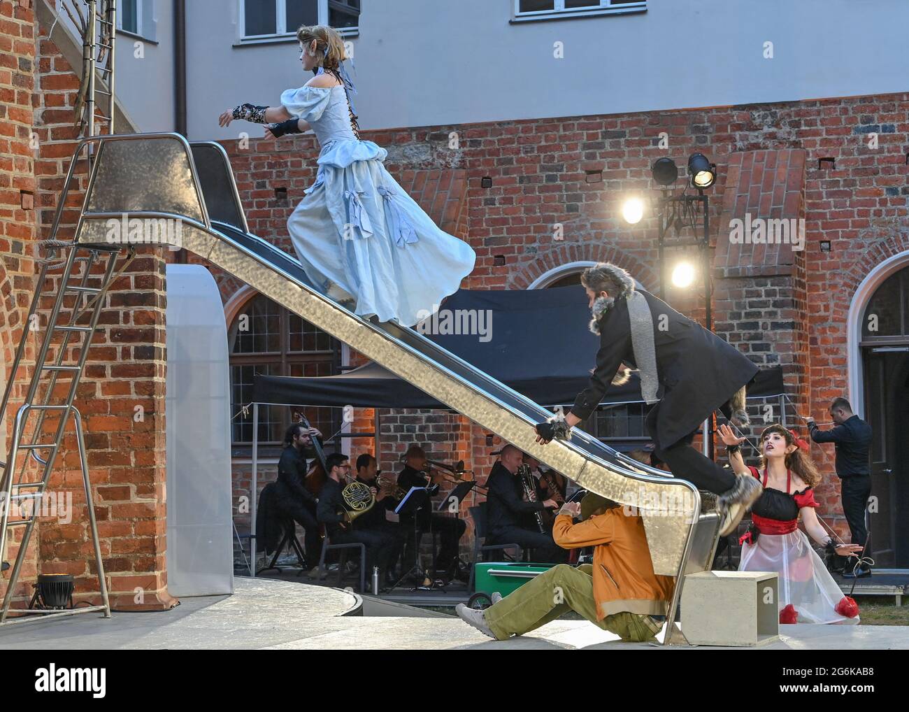 06. Juli 2021, Brandenburg, Neuzelle: Schauspieler üben während einer Probe für die Oper "der Liebestrank" von Gaetano Donizetti in einer Fassung von Wolfgang Böhmer im Kreuzhof des Klosters Neuzelle. Am 08.07.2021 findet die Premiere dieser Oper statt. Große italienische Oper mit allem, was dazu gehört! Verbotene und geheime Liebe, Intrigen, Rivalität und ein echter Liebestrank. Nemorino liebt Adina, aber alles steht gegen diese Vereinigung. Das moderne dramaturgische Gewand der Oper oder Spree 2021 fasst das Wesen der fünf Hauptfiguren der Oper ohne Chöre oder Unterstützung zusammen Stockfoto