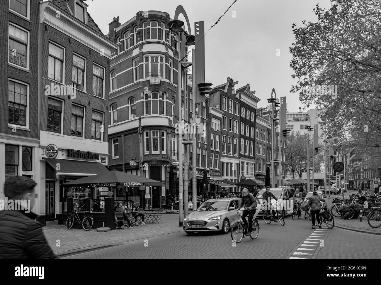 AMSTERDAM, NIEDERLANDE. 06. JUNI 2021. Schöne Fassaden der alten holländischen Gebäude. Restaurants auf der Straße. Schwarzweiß-Fotografie. Stockfoto