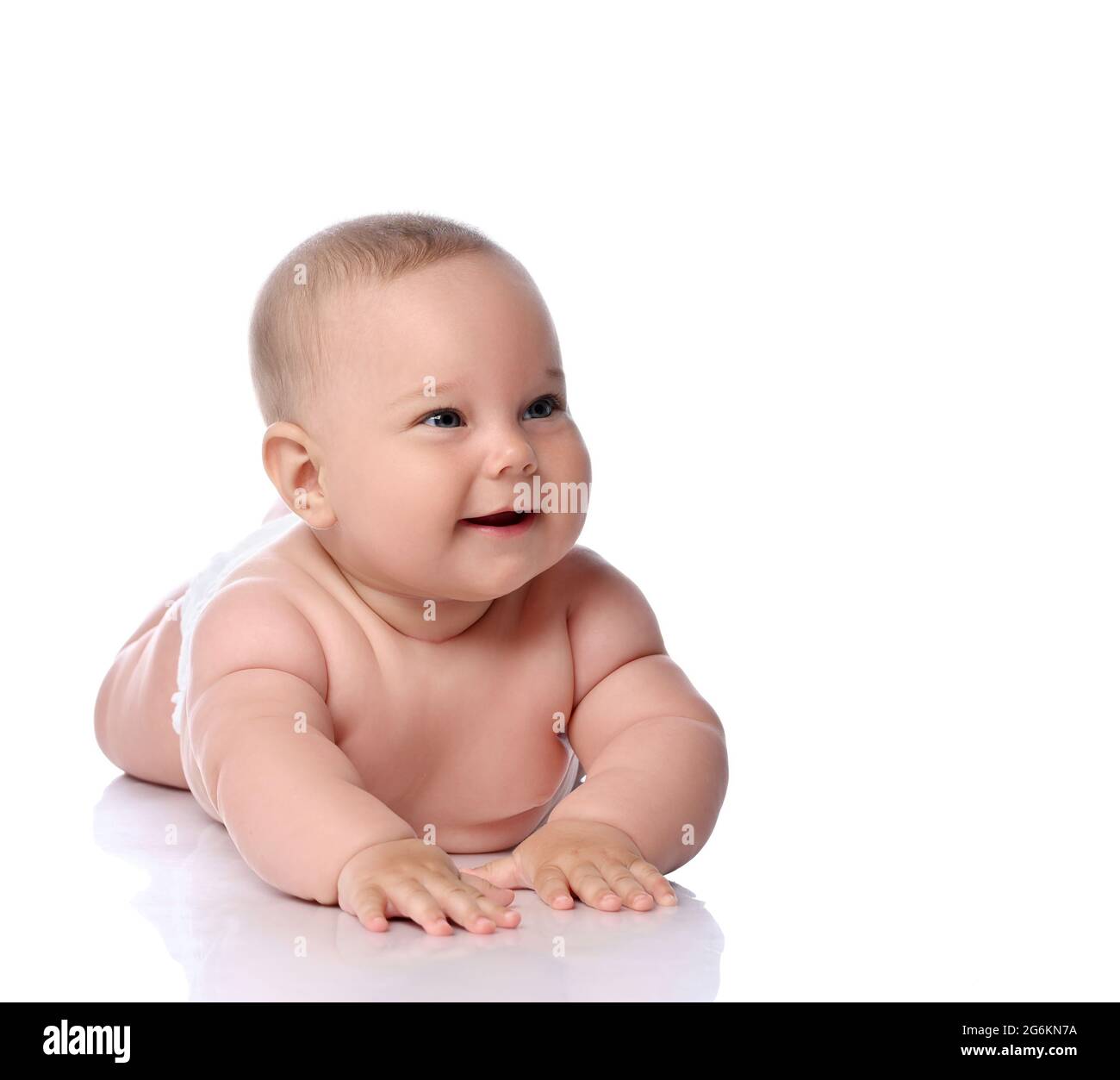 Glücklich Kleinkind Baby Mädchen Kind in Windel liegt auf ihrem Bauch, Bauch, kriechen, lachen und kichern Stockfoto