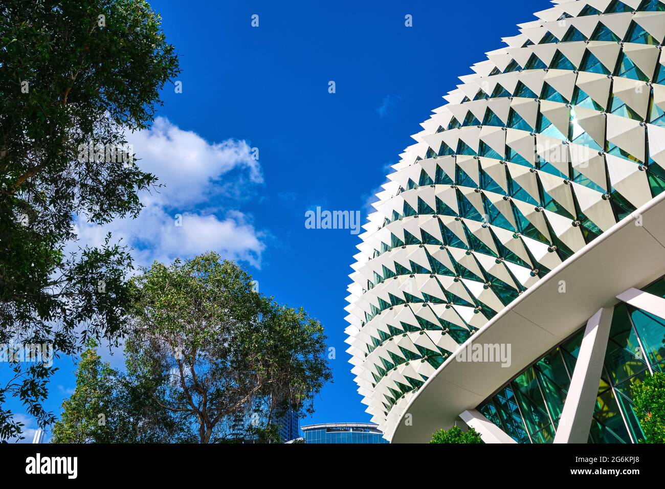 Details zum futuristischen Dach des Esplanade Arts Center oder den Theatern an der Bucht, Singapur an klaren, sonnigen Tagen, Bäumen in sattem Laub. Stockfoto