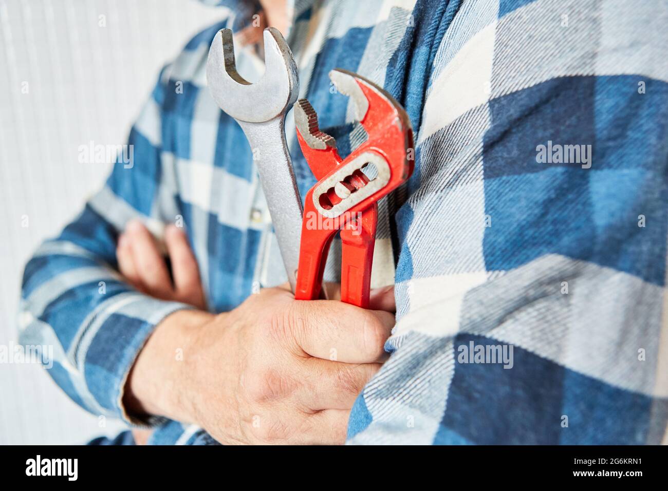 Handwerker mit Gabelschlüssel und Rohrschlüssel als Symbol für Handwerk und Service Stockfoto