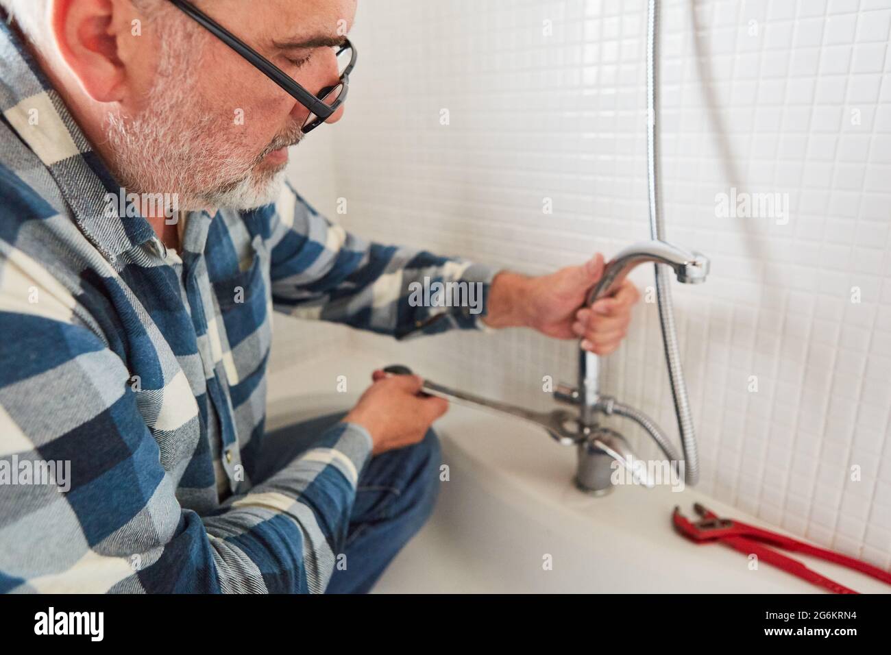 Klempner installiert Armaturen mit Wasserhähnen für Badewannen und Duschen Stockfoto