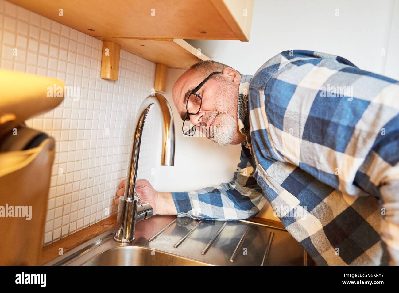Handwerker als Klempner für Wasserhähne und Spülbecken in einer Küche Stockfoto