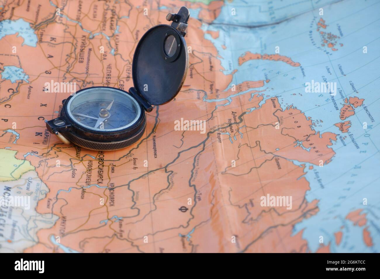 Alter Kompass auf der russischsprachigen Weltkarte. Konzept. Stockfoto