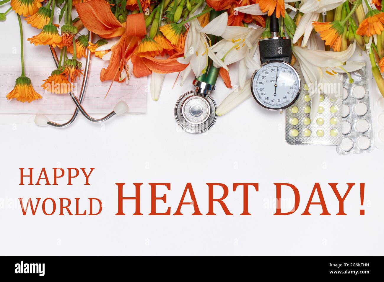 Eine Grußkarte mit Text Happy World Heart Day – Tablets, Sphingomanometer und Phonendoskop mit Blumen auf Weiß. Stockfoto