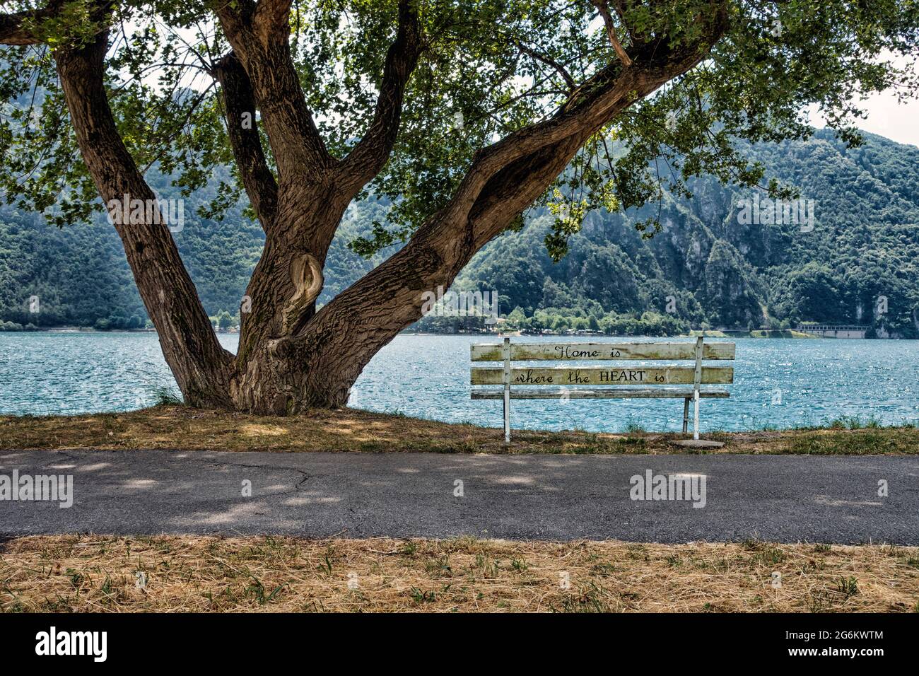 Alte weiße Bank mit einem Diktum auf sie in der Stadt Anfo am Ufer des Idrosees in Italien Stockfoto