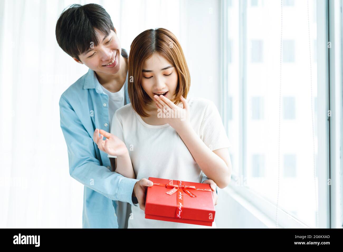 Bild eines Freundes, der seiner Freundin am Valentinstag ein Geschenk macht Stockfoto