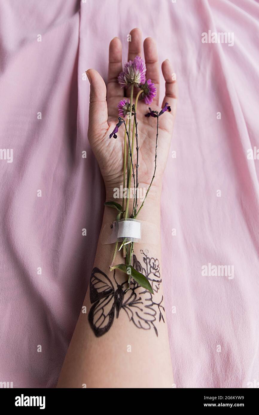 Arm mit Tattoos und Wildblumen II Stockfoto