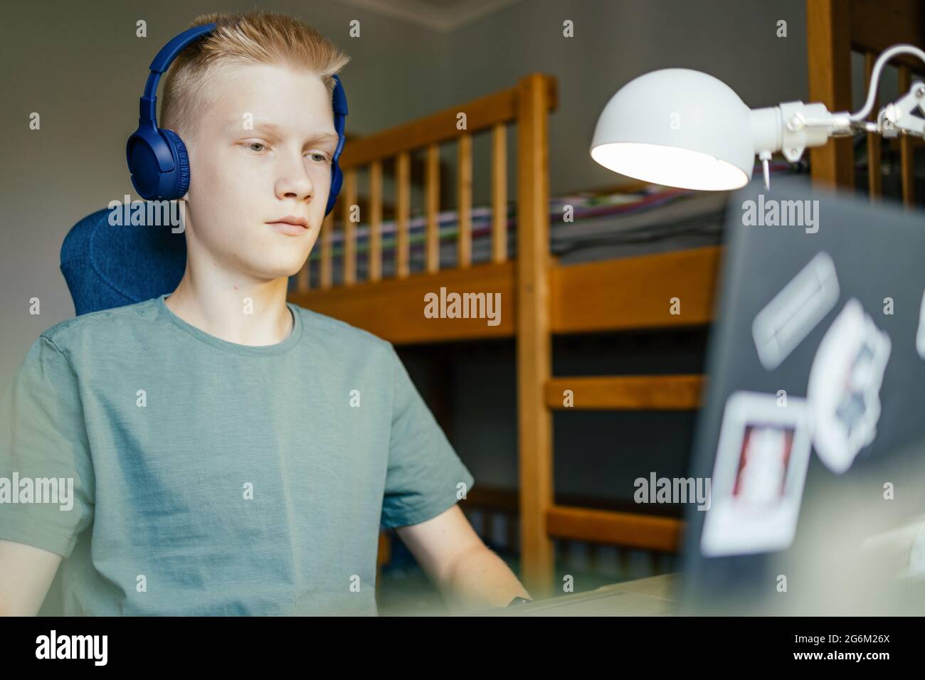 Junge Schülerin, die online Unterricht am Laptop ansieht und zu Hause studiert. Stockfoto