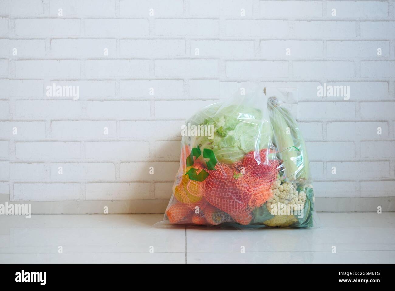 Recycelte Pfeile auf einer Einkaufstasche mit Gemüse auf einem Boden Stockfoto
