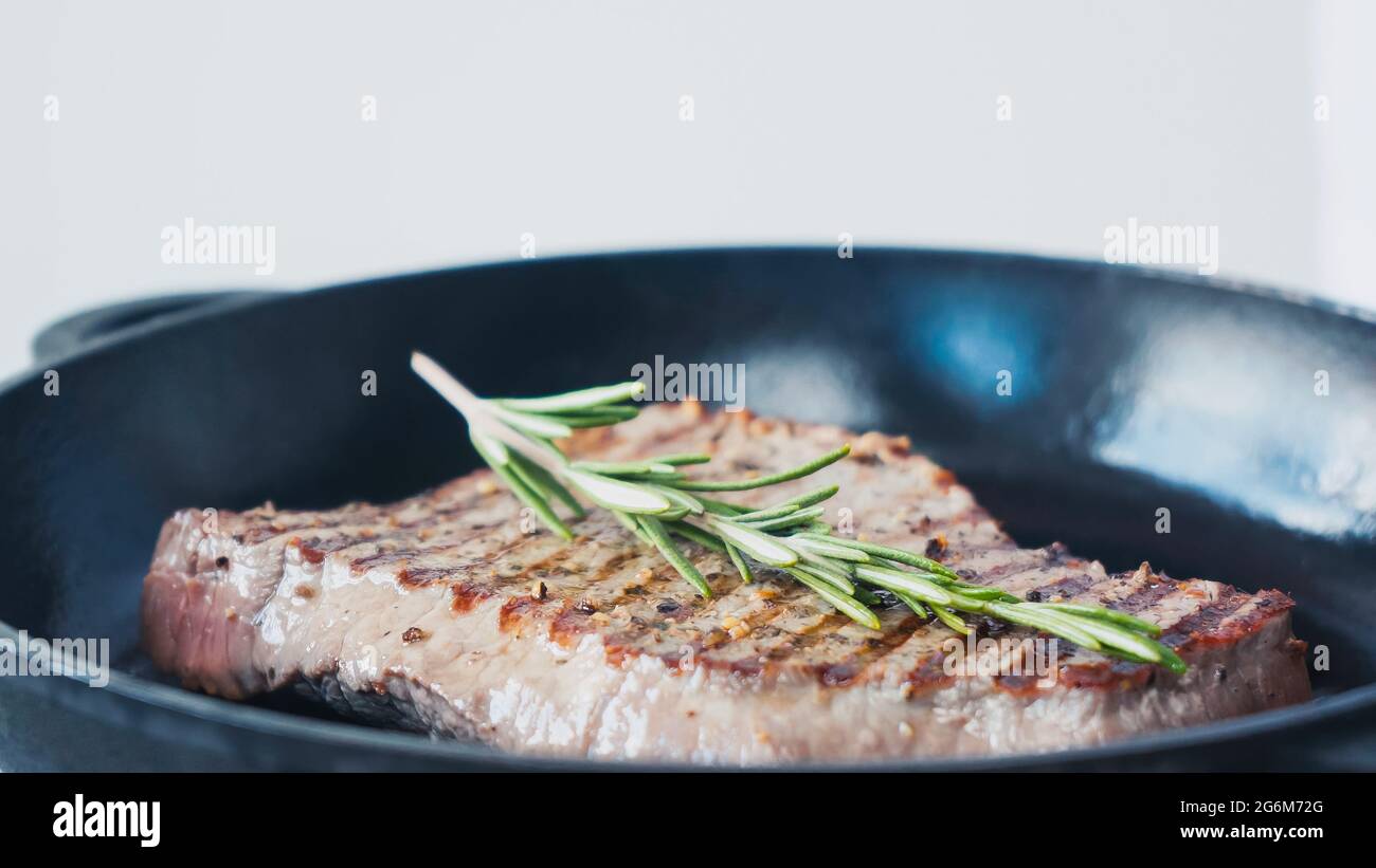 Nahaufnahme von grünem Rosmarinzweig auf gebratenem Rindersteak Stockfoto