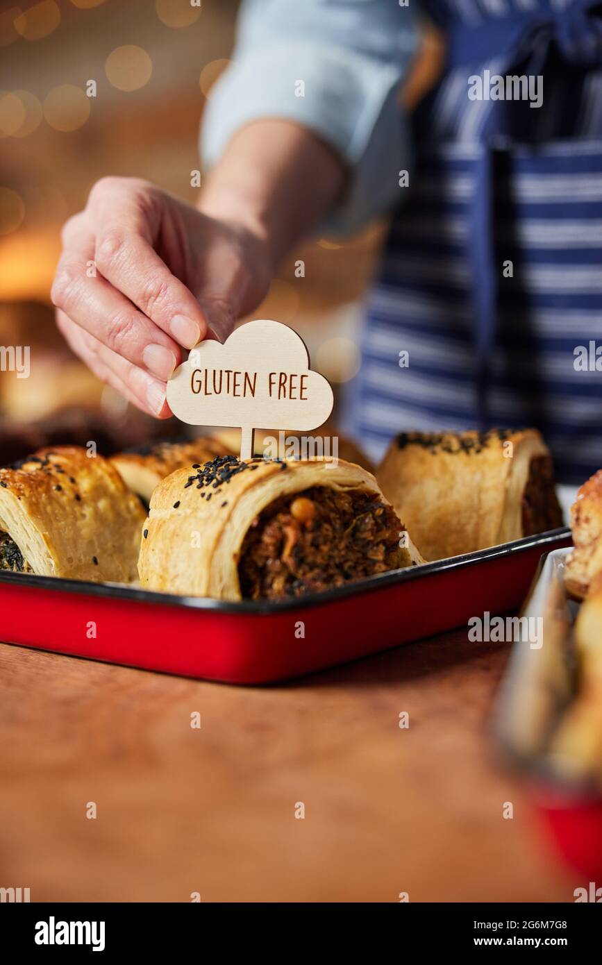 Verkaufsassistent In Der Bäckerei, Die Gluten Free Label Frisch Zubereitet Gebackene Herzhafte Brötchen Stockfoto