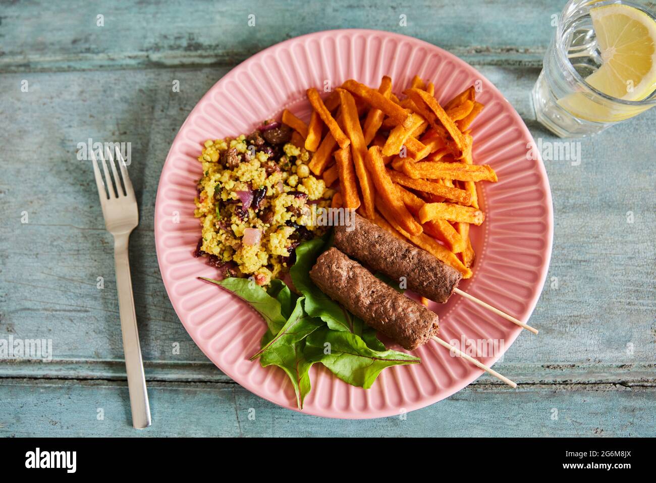 Veganes Gericht Auf Dem Teller Mit Kofta-Kebabs Auf Pflanzlicher Basis Mit Süßkartoffeln Und Couscous Und Salat Stockfoto