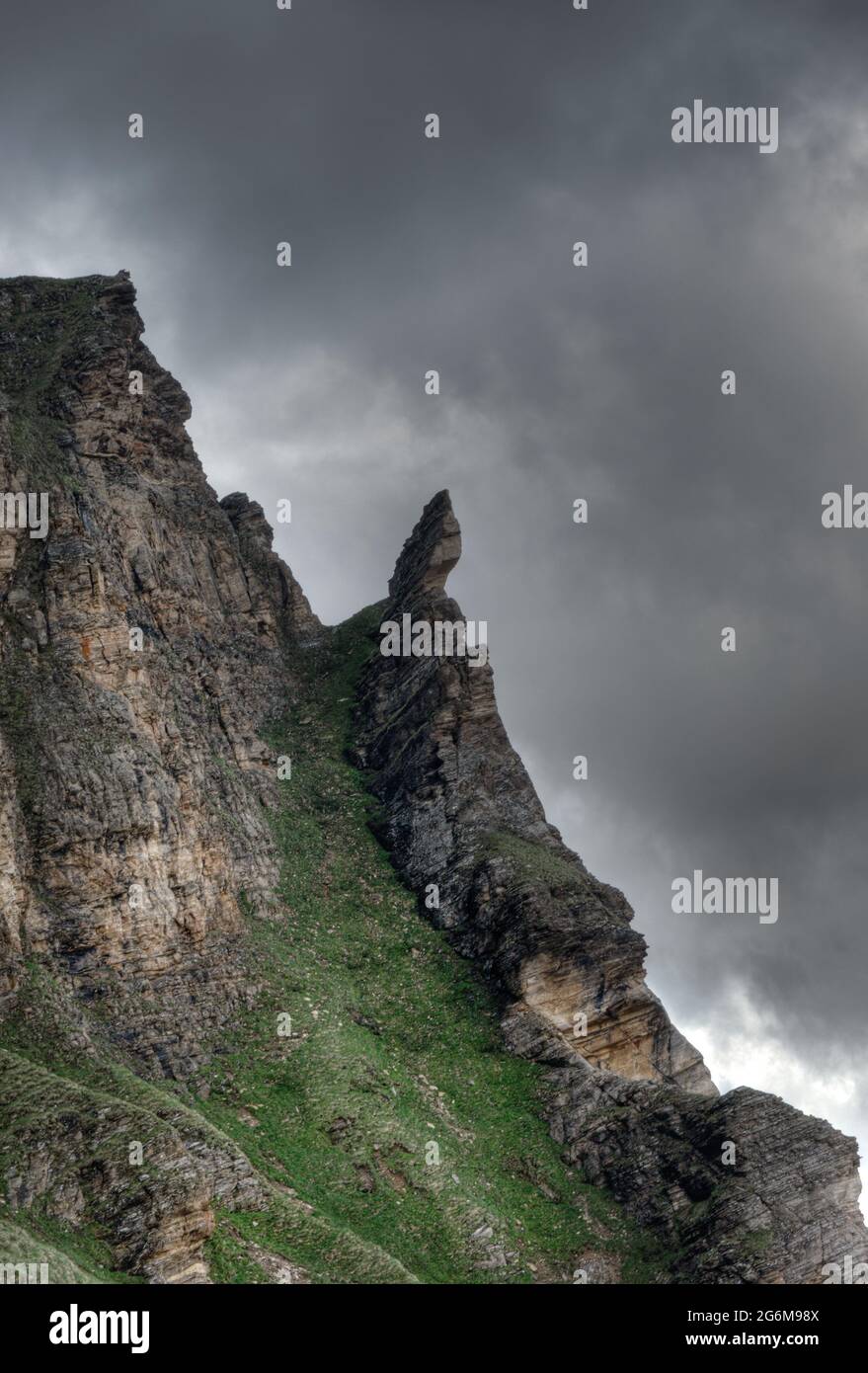 Launisch geformter Fels in den Bergen unter bedrohlichem Himmel in den italienischen Alpen Stockfoto