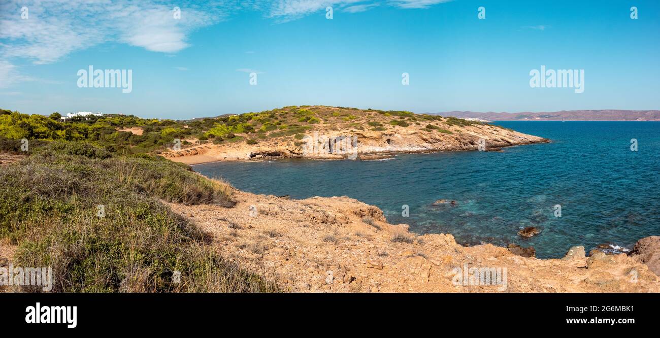 Felsiges Panorama, mit grünen Büschen, Klippen und wildem Strand an der Küste in der Nähe von Athen, Griechenland. Lebendige bunte Sommer Blick mit blauen klaren Mediterra Stockfoto